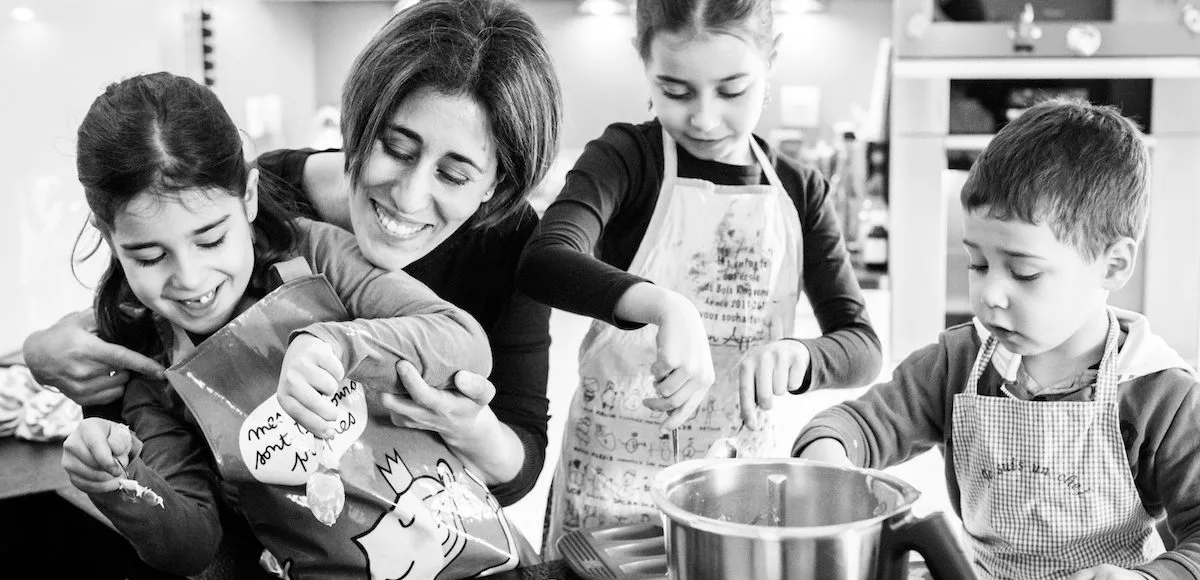 Famille de trois qui cuisine ensemble dans la cuisine, moment complice