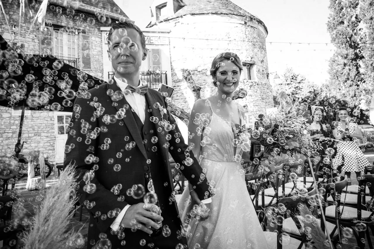 Sortie de cérémonie sous les confettis devant un château, mariage dans le Beaujolais