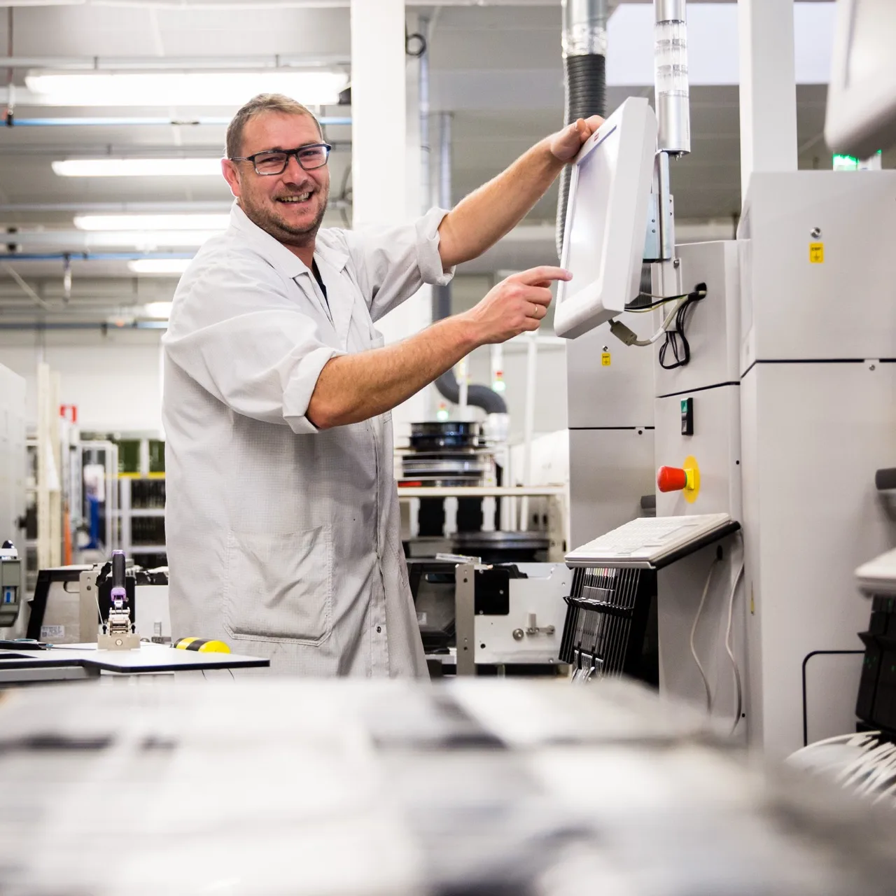 Portrait d'un technicien souriant à son poste de travail, photo de métier à Lyon