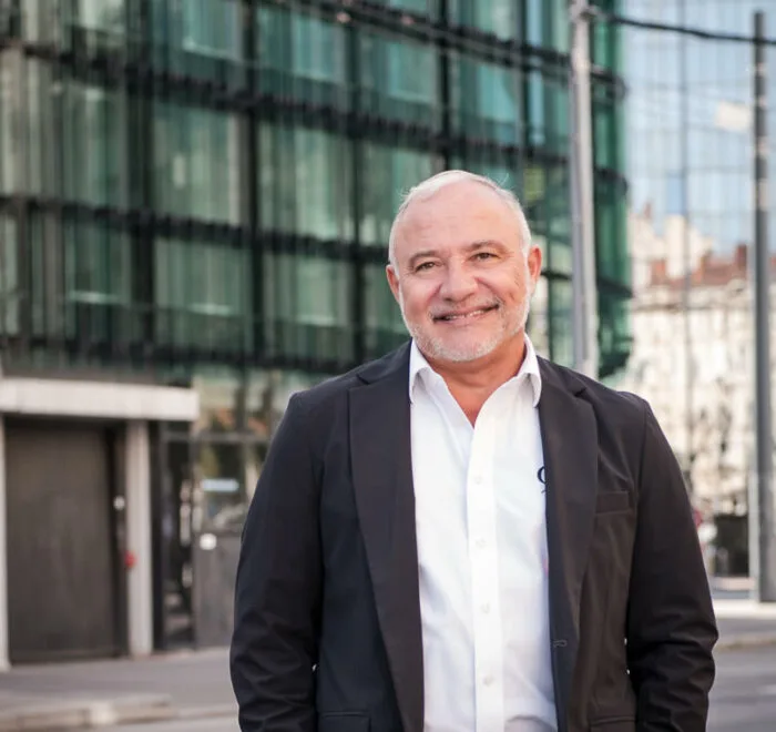 Portrait professionnel d'un dirigeant devant un immeuble de bureaux à Lyon