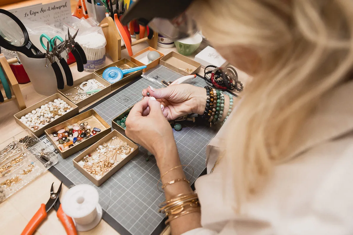 Créatrice de bijoux triant ses perles dans son atelier près de Lyon