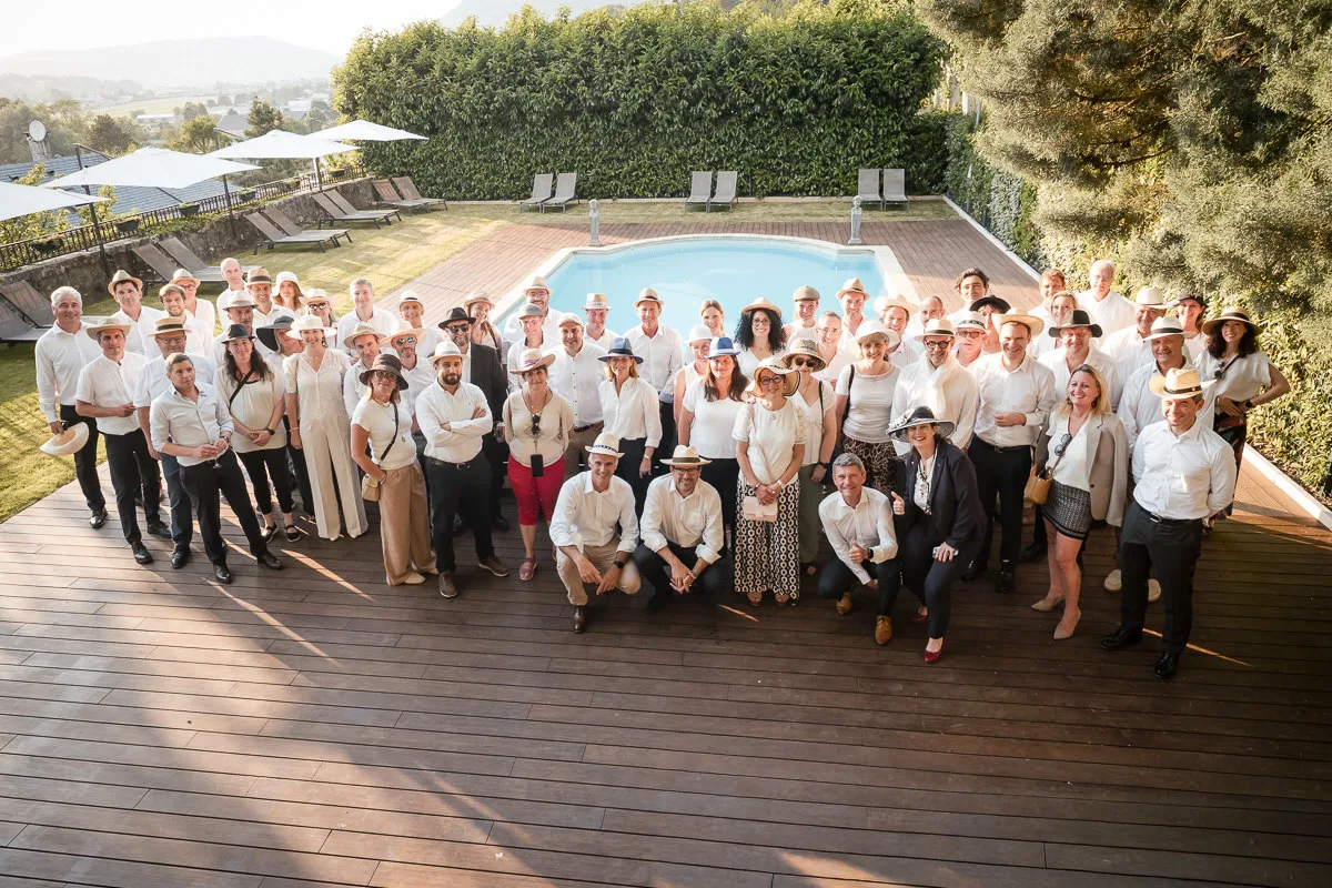 Photo de groupe d'une équipe entière réunie autour d'une piscine lors d'un séminaire