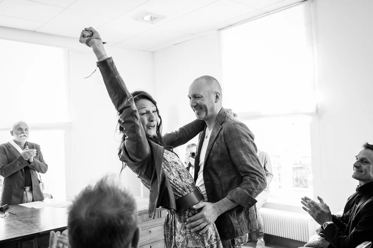 Mariés sortant de la mairie le poing levé, applaudis par leurs proches, mariage à Lyon